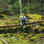 He relaxes on fallen tree and hosts meeting on laptop